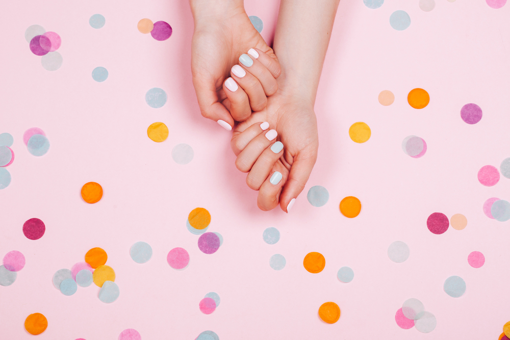 colorful round nails on a pink and colorful polkadot background