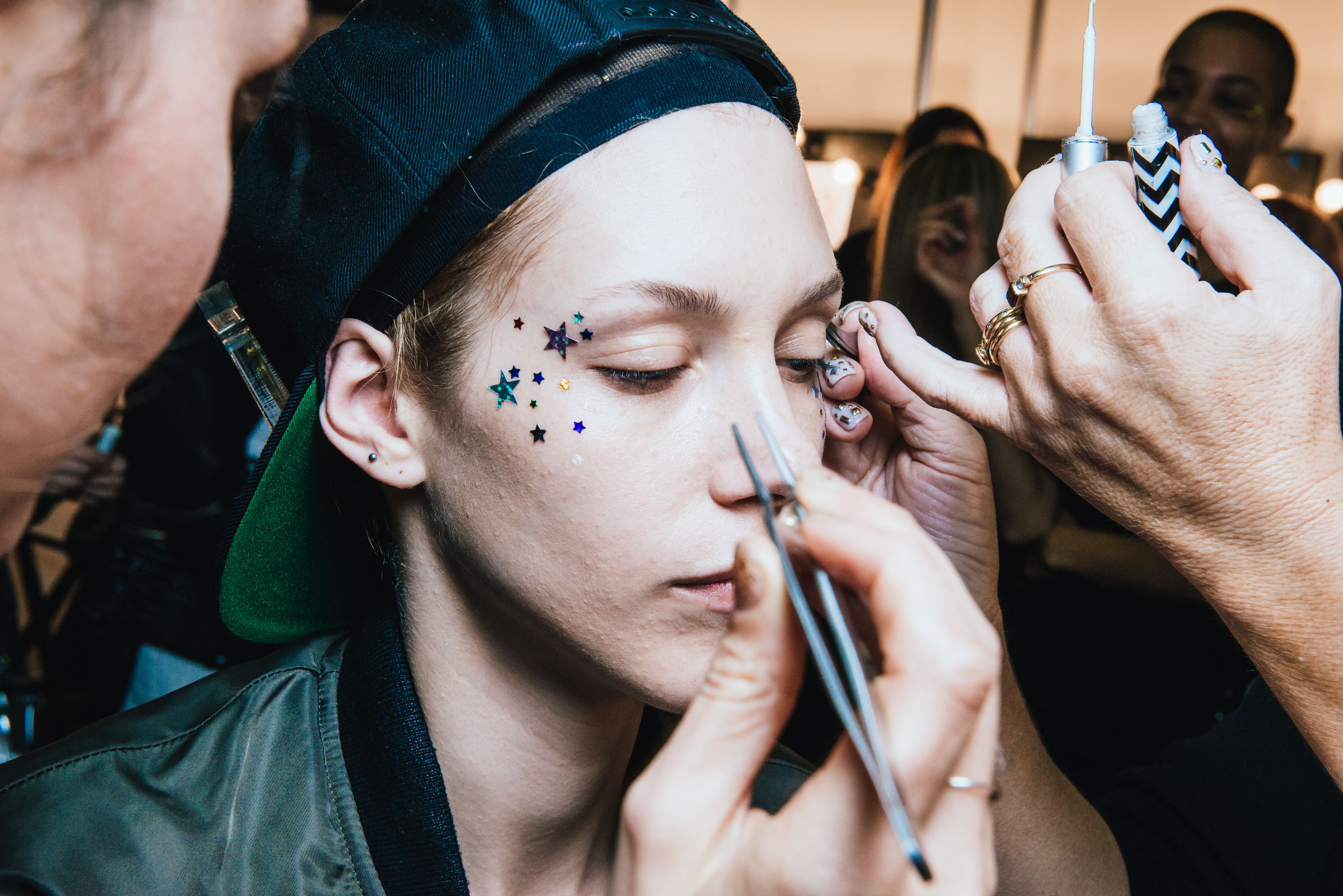 Makeup artists work on a model in a beauty convention