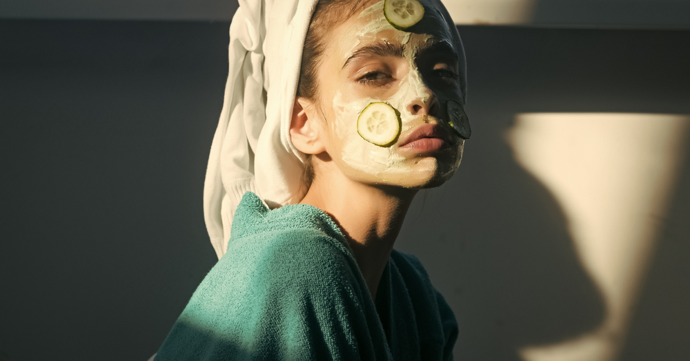 girl doing self care with a mask and cucumbers on her face